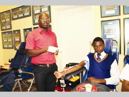 Bookie Dube (SANBS) helps Chris Makgoka to donate blood at the Capricorn High School blood drive last Wednesday.