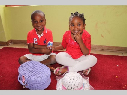 Kgomotso Msiza and Neo Mokwena share a box of smarties on Valentine's Day at the Share Joy Day Care picnic.