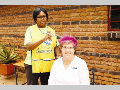 Pam Smith (Pepps Polokwane College, functions and marketing manager) leads the way for the learners and teachers and has her hair sprayed during the Cansa Shavathon at the school.