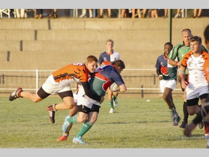 Frank Julius van Tom Naudé probeer aanstormende PHS Barbarians-speler, Tyrone Thompson, stuit in hul wedstryd tydens die Kia Bosveld Rugbyfees se eindronde verlede Woensdag.