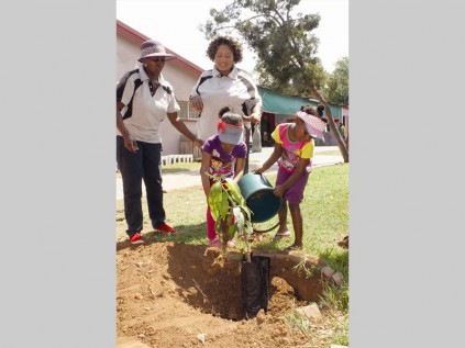 Reitumetse Mannye and Boledi Mphahlele plant trees with principal, Josephine Kimuthia and teacher, Margaret Maswanganyi.