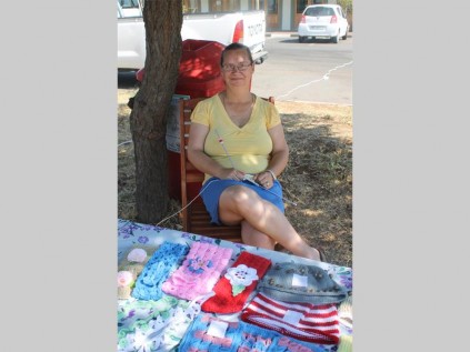 Anet Oosthuizen gebruik dun naalde om fyn werk vir baba klere te brei wat sy dan weer verkoop.
