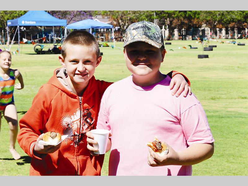 Frankie Kubannek en Phil Fourie stil hul honger met 'n worsbroodjie of twee by Oosskool se pretdag. Sien foto's en videos op www.reviewonline.co.za.