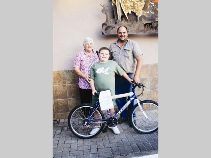 Dohan Bezuidenhout did not expect to win a bicycle. With him is his grandmother Nellie Steyn and Hannes Willemse (Nguni Grill, owner).