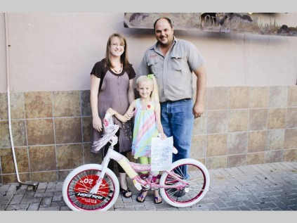 Elis-marie du Toit smiles from ear to ear as she holds on to her new bicycle. With her is her mother Sonica and Hannes Willemse (Nguni Grill, owner).