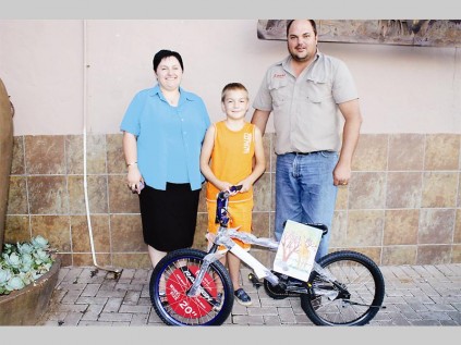 Charlene Human with her son Reghardt Human (8). He was very surprised to win a bicycle. With them is Hannes Willemse (Nguni Grill, owner).