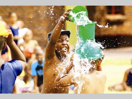 Tigani Nukeri pours water on one of his school mates during Pepps Polokwane Preparatory School's water fun day.