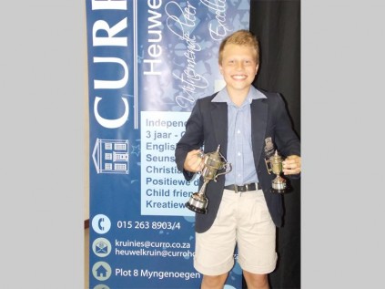 Henco Bandenhorst wys die trofeë wat hy gewen het as Curro Heuwelkruin Laerskool se sportseun van die jaar. Hy deel ook die trofee vir die seunssportster met Gerhard van Zyl. Hy het hierdie trofeë gewen tydens die skool se prysuitdeling in Oktober.
