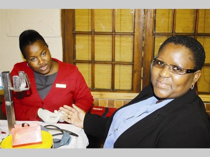 Thatcher Malesa (SANBS, executive nurse) tests Tebogo Legodi's iron levels to check whether it is safe for her to donate blood during Bolivia Lodge's blood drive.