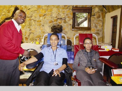 Rhulani Maluleke (SANBS, enrolled nurse) helps Salome Monama and Fundi Xulu to donate blood.