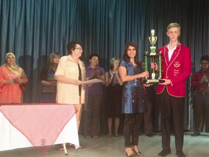 Gr. 12 learner, Nicolai van Niekerk, holds his Dux trophy assisted by Tasneem Mosam (teacher). 