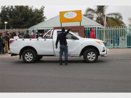 Police and traffic officials direct traffic in Biccard Street to ensure the safety of bidders as they submit the last bids for the  schools feeding scheme tender.