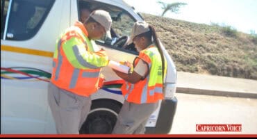 Traffic officers check a driver's documentation.