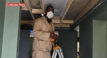 Avhafarei Eric Mangavha standing on a ladder while working.