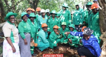 Community members stand near a local spring.