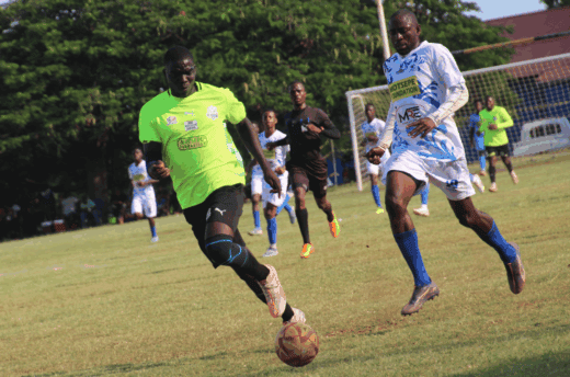 Two soccer players chase a loose ball.