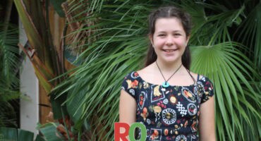 A girl stands in a garden.