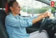 Woman driving in car, looking surprised.