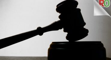 a judges' gavel resting on the gavel block