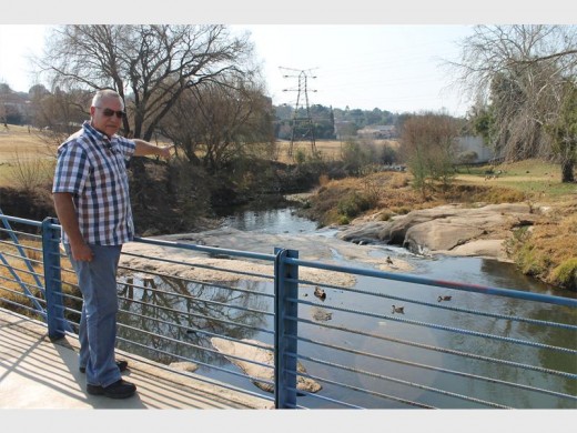 Ward 117 councillor Tim Truluck points to where people used to cross from Parkhurst to Victory Park before the blue footbridge was put up.