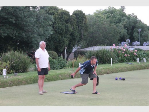 Two team members look very serious in a game of bowls.