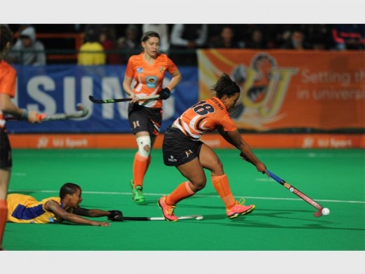 Cheneal Raubenheimer of  UJ hits the ball with Belinda Plaatjies of Wits trailing behind her during Varsity Hockey. Photo supplied.