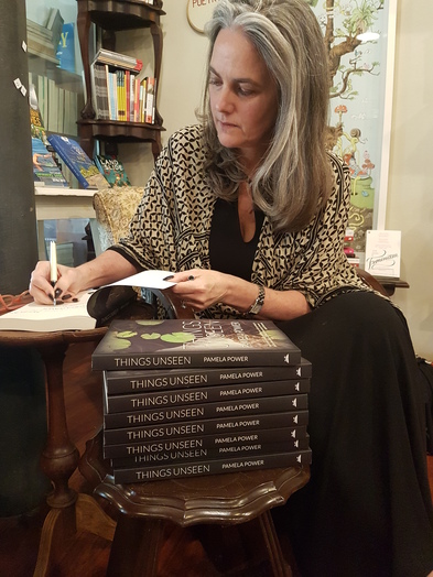 Pamela Power signs a stack of books at Love Books.