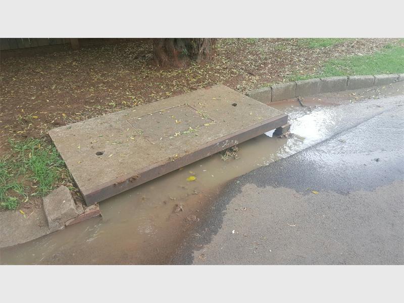 The blocked stormwater drain fills street with water. Photo: Supplied.