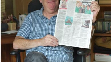 Gus Silber holds a copy of the Norhtcliff Melville Times