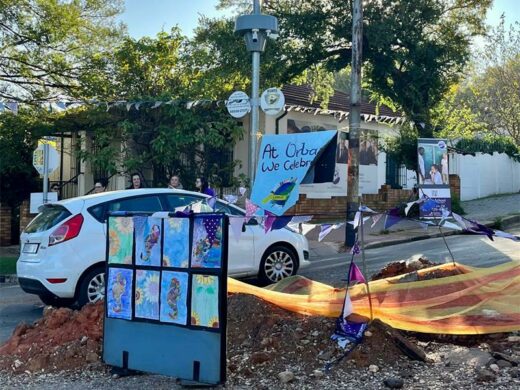 Cars drive by the donga surrounded by art.