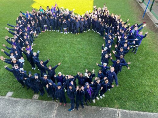 Children stand in the shape of a heart.
