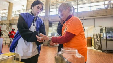 Astri Leroy of the spider club hands over a 'gogga' to a student.