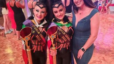 Jada Croll and Caitlyn Nortje hold their trophies. They're pictured with their coach Shannon Dunbar at the Freestyle World Championships in Blackpool, UK.