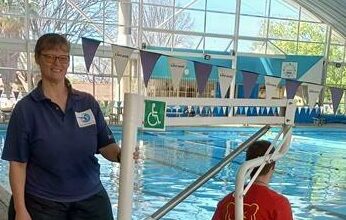 Shandre Bridle, who owns We Swim 4 Life, and her son test out the newly fixed and reinstalled disability chair at the Linden pool.