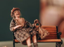 A character doll sits on a bench laughing. Photo: Neo Phashe