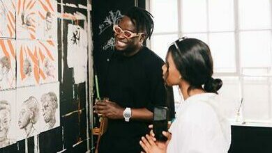 Fhatuwani Mukheli chats with a guest while looking at one of his art pieces.