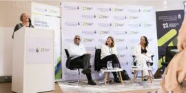 Phiroshaw Camays Life Partner Anne Gordon (podium) as Professor Imraan Valodia, Ferial Haffajee and Professor Lynn Morris sit as a panel.