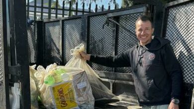Alex Roberts loads the van with rubbish.