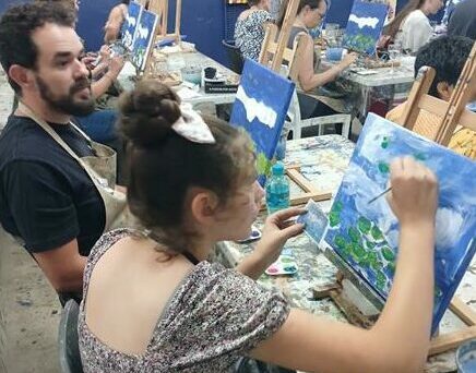 Raphael and Hannah Garcia da Costa paint alongside each other.