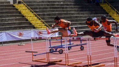 Athletes run in 110m hurdles.