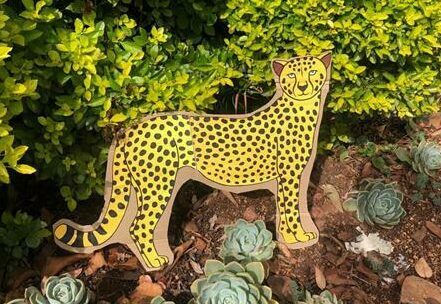 A cheetah stands among the foliage.