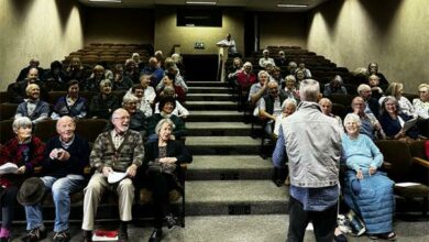 The audience awaits the screening of the documentary.