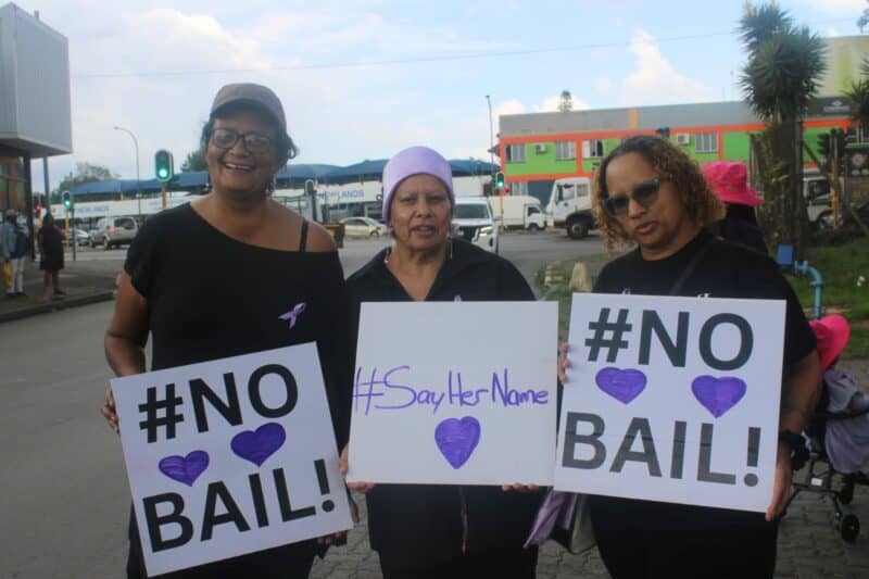 Women gathered in solidarity calling for action, safety, and an end to gender-based violence.