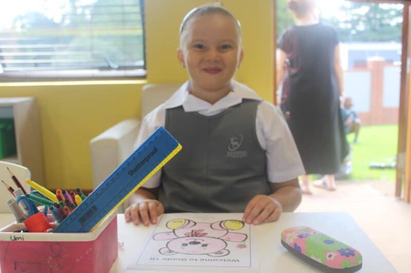 First-day smiles were captured beside tiny desks as pupils began their school journey.