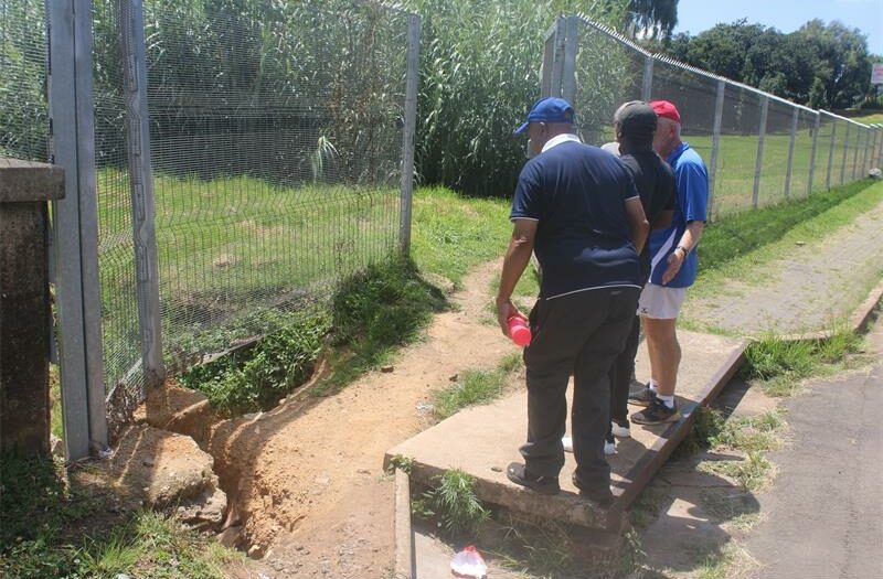 A blocked drainage pipe beneath the bridge is being linked to ongoing erosion affecting the pedestrian walkway.