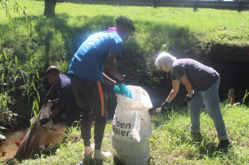 A chance collaboration brought environmental groups together as volunteers worked side by side to clear waste from a neglected stream and restore a public space.