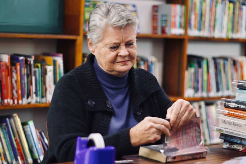 Maureen Freeman places Sellotape on books as she covers them on July 7, 2026, at the Linden Library. Photo: Neo Phashe