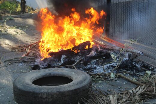 A burning tyre and tree branches block the entrance to Pikitup's Waterval depot on July 8, 2026. Photo: Waydon Jacobs