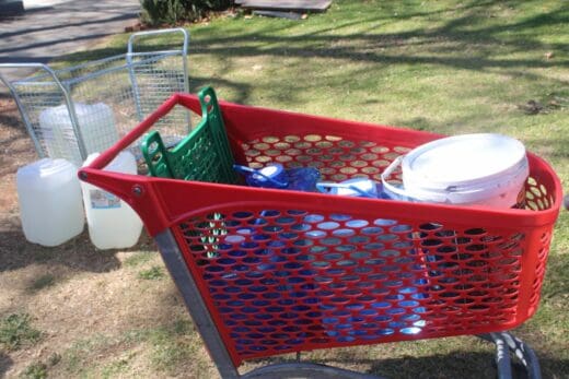 Empty containers and water bottles are loaded into a shopping trolley as residents prepare to collect emergency water from a Johannesburg Water tanker during the prolonged outage. Photo: Waydon Jacobs