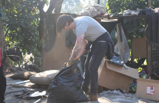 Bradley Kirton cleans up around a makeshift tent in Killarney on July 7, 2026. Photo: Asanda Matlhare